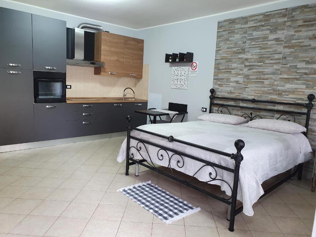 a bedroom with a large bed and a kitchen at B e B House in Castellanza