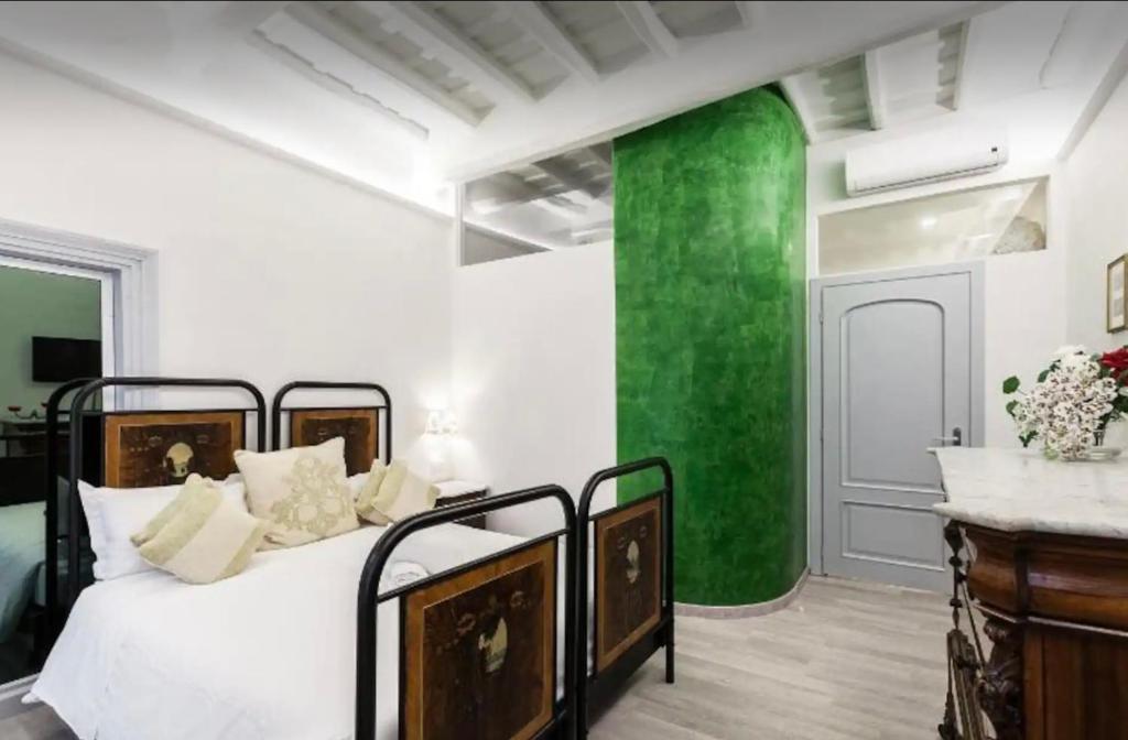 1 dormitorio con cama y pared verde en Vittoria Suite, en Roma