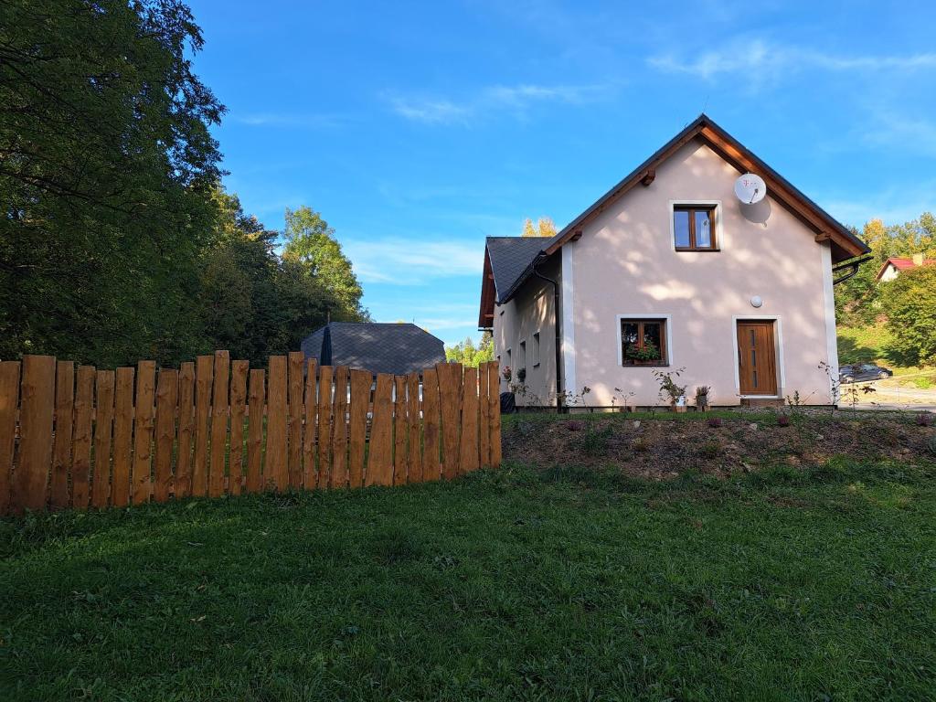 une petite maison blanche derrière une clôture en bois dans l'établissement Chalupa Petra, à Dolní Morava