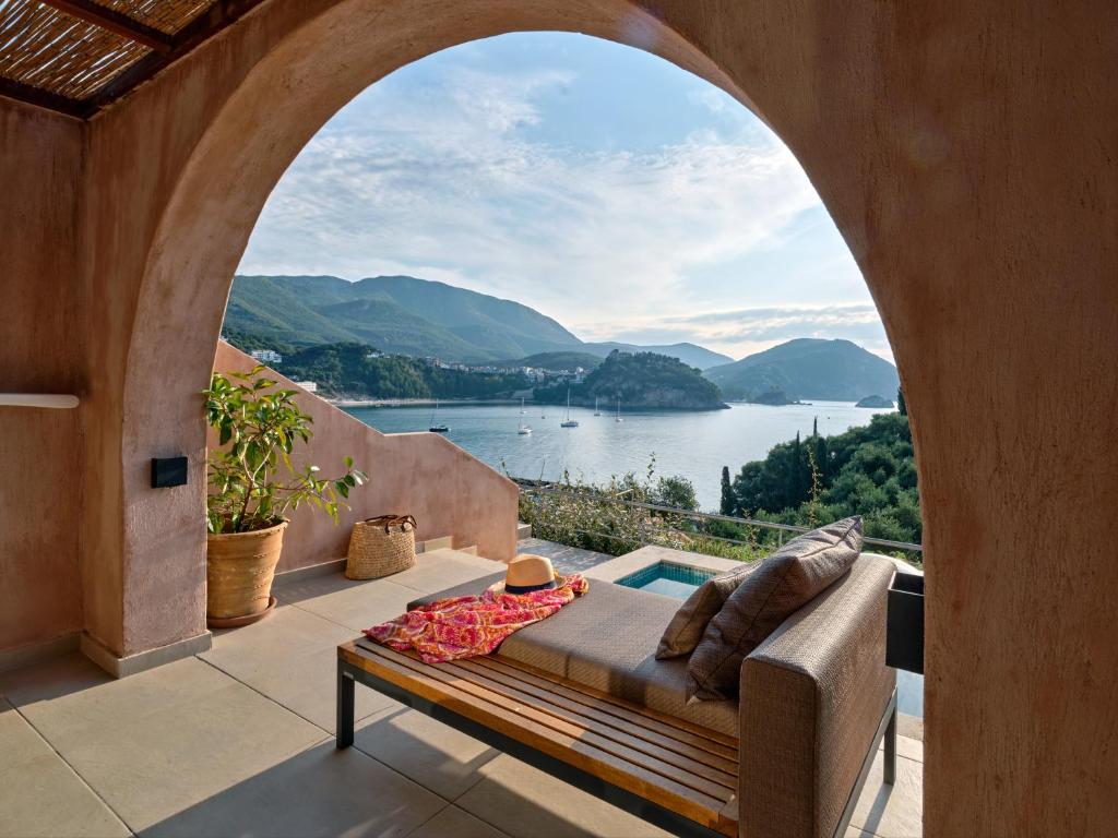 a patio with a couch and a view of a lake at ISAVORIA ECO CHIC RESORT in Parga