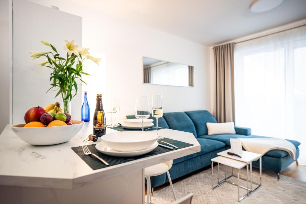 德勒斯登的住宿－NK Apartments - Hafencity Dresden mit Elbblick - Modern & Zentral，客厅设有蓝色的沙发和带水果的桌子。