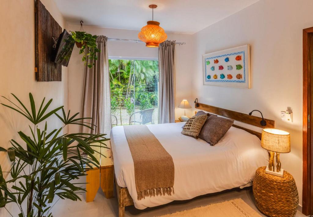 um quarto com uma cama e uma janela em Itamambuca Eco Resort em Ubatuba