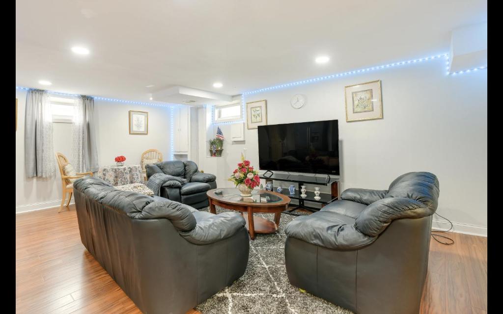a living room with couches and a flat screen tv at Splendid Cheerful 2-bedroom residential in Hyattsville
