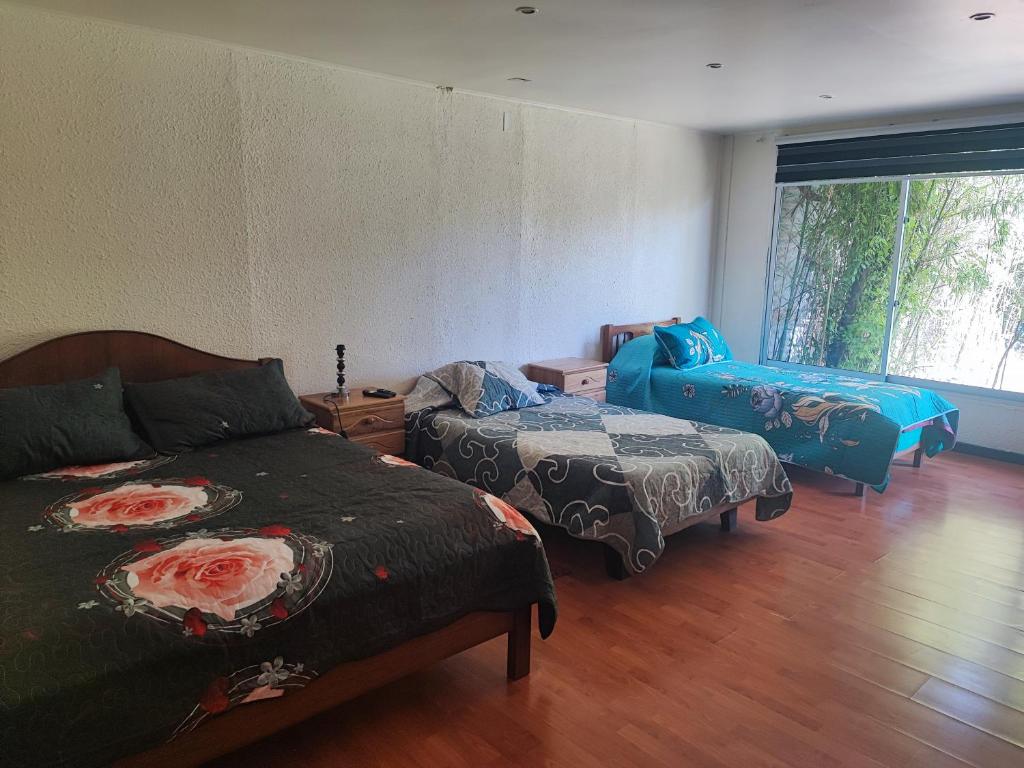 sala de estar con 2 camas y sofá en Hostal Fernanda, en Santa Cruz