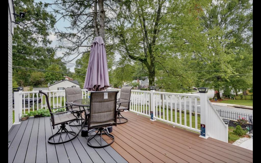 eine Terrasse mit einem Tisch und einem Sonnenschirm auf einer Terrasse in der Unterkunft Splendid Cheerful 2-bedroom residential in Hyattsville