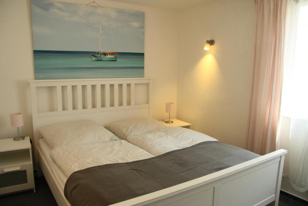 1 dormitorio con 1 cama con una pintura en la pared en Freundliches Appartement - Bitte Angaben zum Gastgeber lesen, en Wehrheim