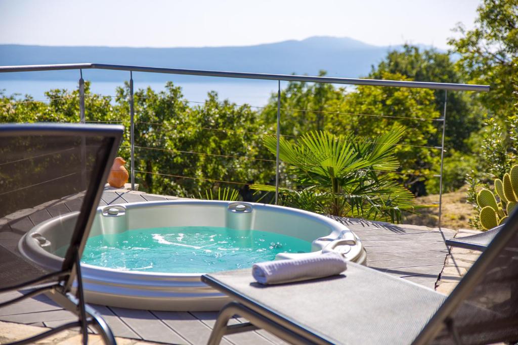a hot tub sitting on a patio with a table at Villa Surina in Mošćenice
