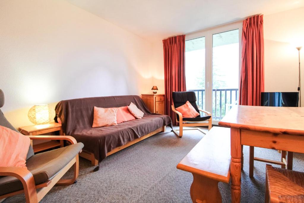 una sala de estar con un sofá y una mesa en Spacious Apartment Iris, Flaine Foret, en Flaine