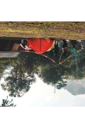 un reflejo de personas y árboles en un charco de agua en glamping camping kamping, en Ungasan