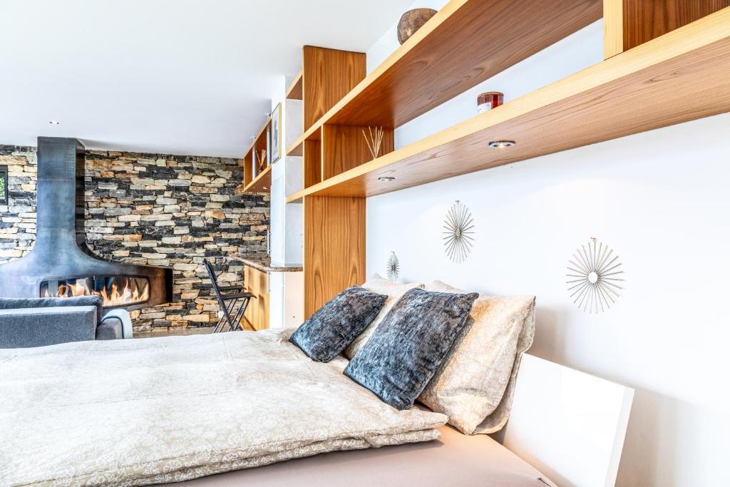 a bedroom with a bed and a brick wall at Loft Savièse in Savièse