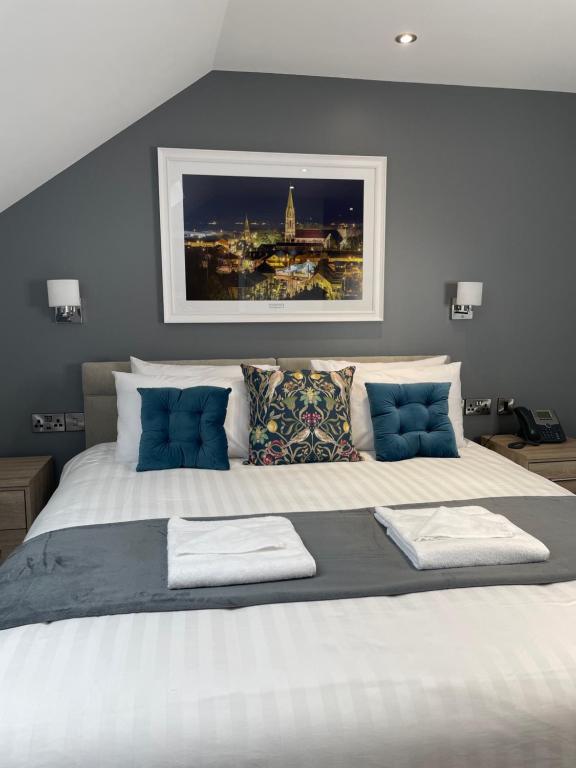 una camera da letto con un grande letto bianco con cuscini blu di The Banks Restaurant and Accommodation a Strabane