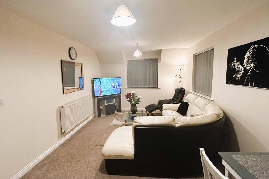 sala de estar con sofá en blanco y negro y TV en 2-Bed spacious apartment - One Ensuite, en Warrington