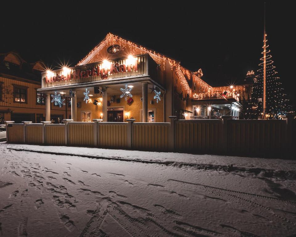Una casa con luces de Navidad en la nieve en Hotell Hertig Karl, en Filipstad