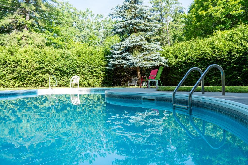 a swimming pool with blue water in a yard at Cobblestone Cottages in Sharbot Lake