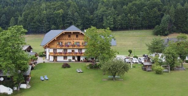 ein großes Gebäude auf einem Feld mit einem Hof in der Unterkunft Hauslhof in St. Wolfgang