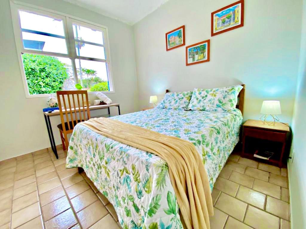 a bedroom with a bed and a window at Garden 437 Suítes in Florianópolis