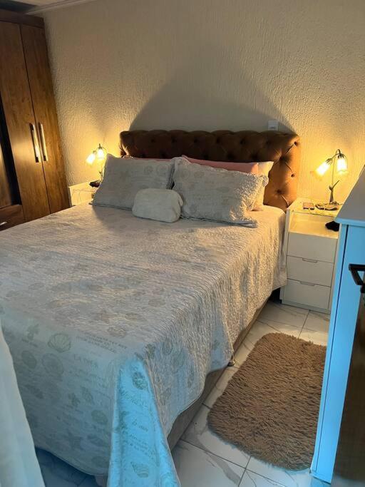 a bedroom with a large bed with two pillows at Bela casa, 2 qtos Taguatinga-DF in Brasília