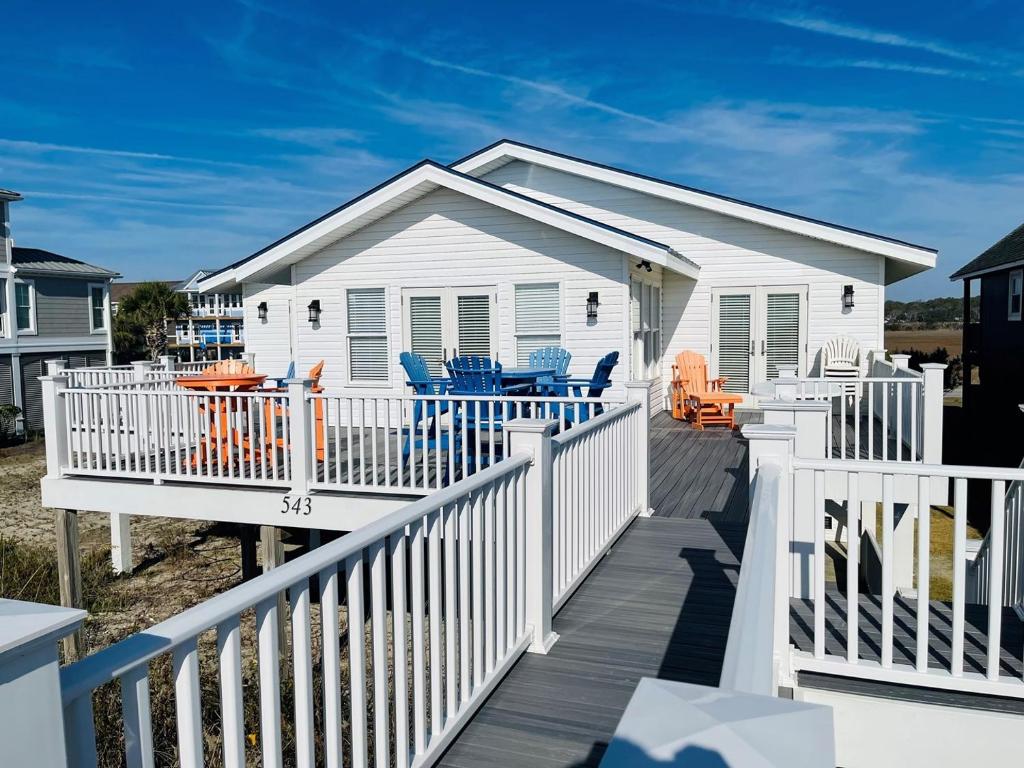 una casa bianca con portico e terrazza di Heaven Sent a Holden Beach