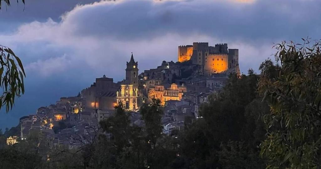 un castillo en la cima de una colina por la noche en A Casa da Paola en Caccamo