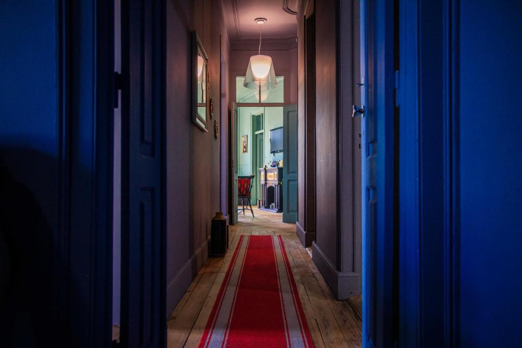 um corredor com um tapete vermelho no chão em Coruche - A casa do Baloiço em Coruche