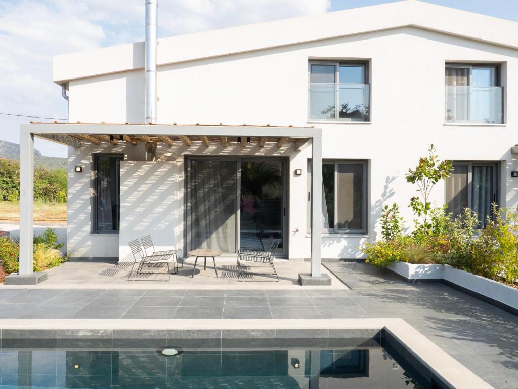 una casa bianca con una piscina di fronte di Sea breeze suites Maistro 4per with private pool a Candia