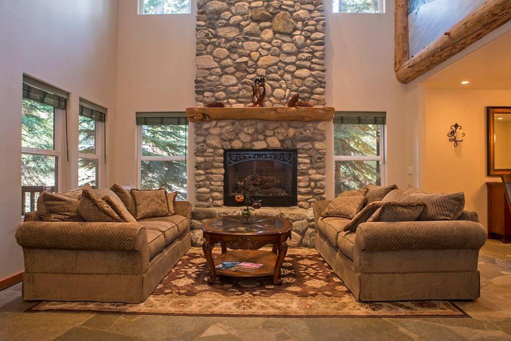 a living room with two couches and a stone fireplace at Big Luxury South Lake Tahoe Home in South Lake Tahoe