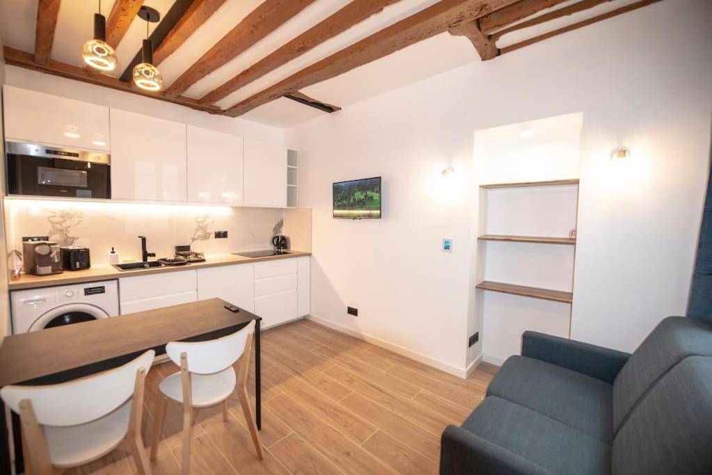 une cuisine et un salon avec une table et un canapé dans l'établissement Appartement cosy Montorgueil (Bonne Nouvelle), à Paris