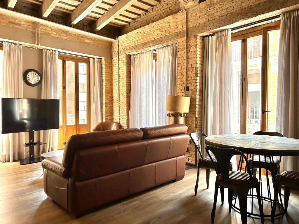 ein Wohnzimmer mit einem Sofa und einem Tisch in der Unterkunft Apartment Plaza de la Merced in Valencia