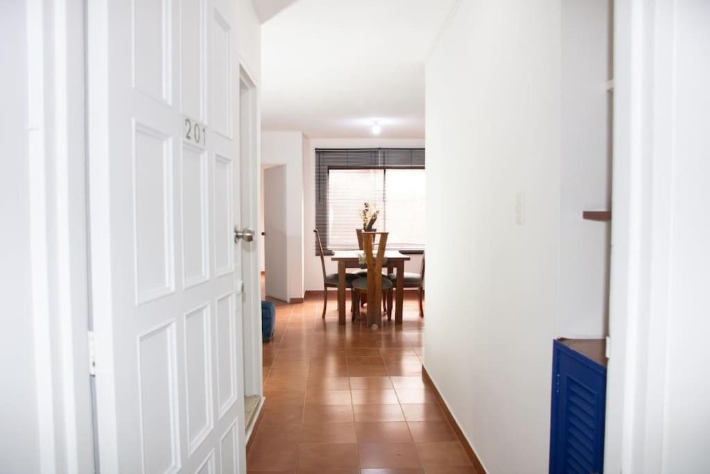 un couloir avec une table à manger et une porte blanche dans l'établissement Aparta estudio acogedor, ubicación Chipichape, à Cali