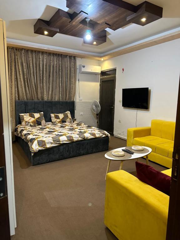 a bedroom with a bed and a couch and a tv at Furnished Studio for rent in Irbid