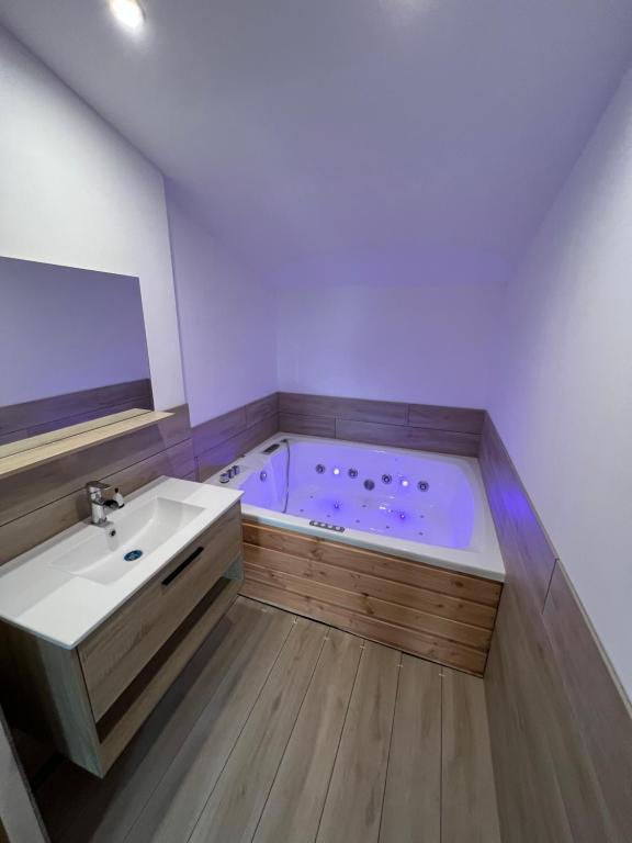 a bathroom with a bath tub and a sink at Jolie maison en pierre esprit chalet avec Jacuzzi in Serdinya