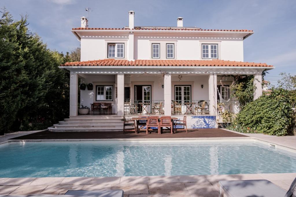 a house with a swimming pool in front of a house at Magnolia B&B in Leiria