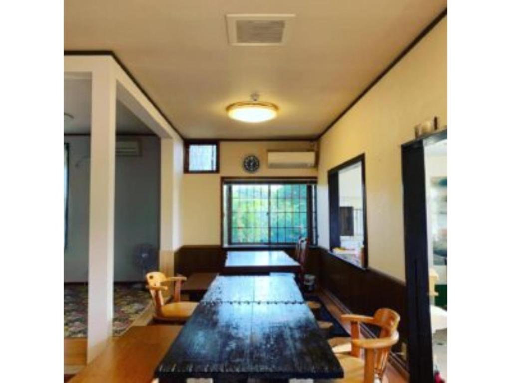 Asobiyahouse Iki - Vacation STAY 30418v في إكي: غرفة طويلة مع طاولة طويلة مع كراسي
