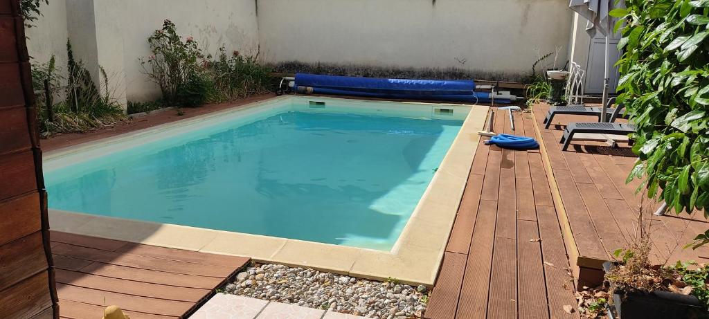 une grande piscine avec une terrasse en bois dans l'établissement Maisonnette avec piscine près de la gare Part Dieu, à Villeurbanne