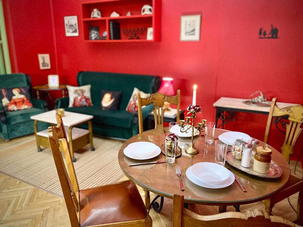 une salle à manger avec une table et un mur rouge dans l'établissement Plovdiv Central Vintage Apartment & Parking, à Plovdiv