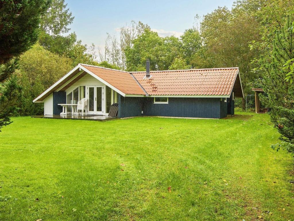 une petite maison avec une grande cour devant elle dans l'établissement Holiday home Fårvang VII, à Fårvang