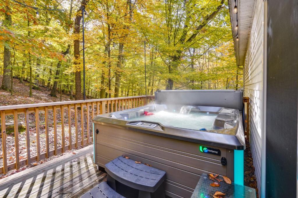 bañera de hidromasaje en una terraza con vistas a los árboles en Charming Ohio Retreat with Deck, Porch and Gas Grill!, en Howard