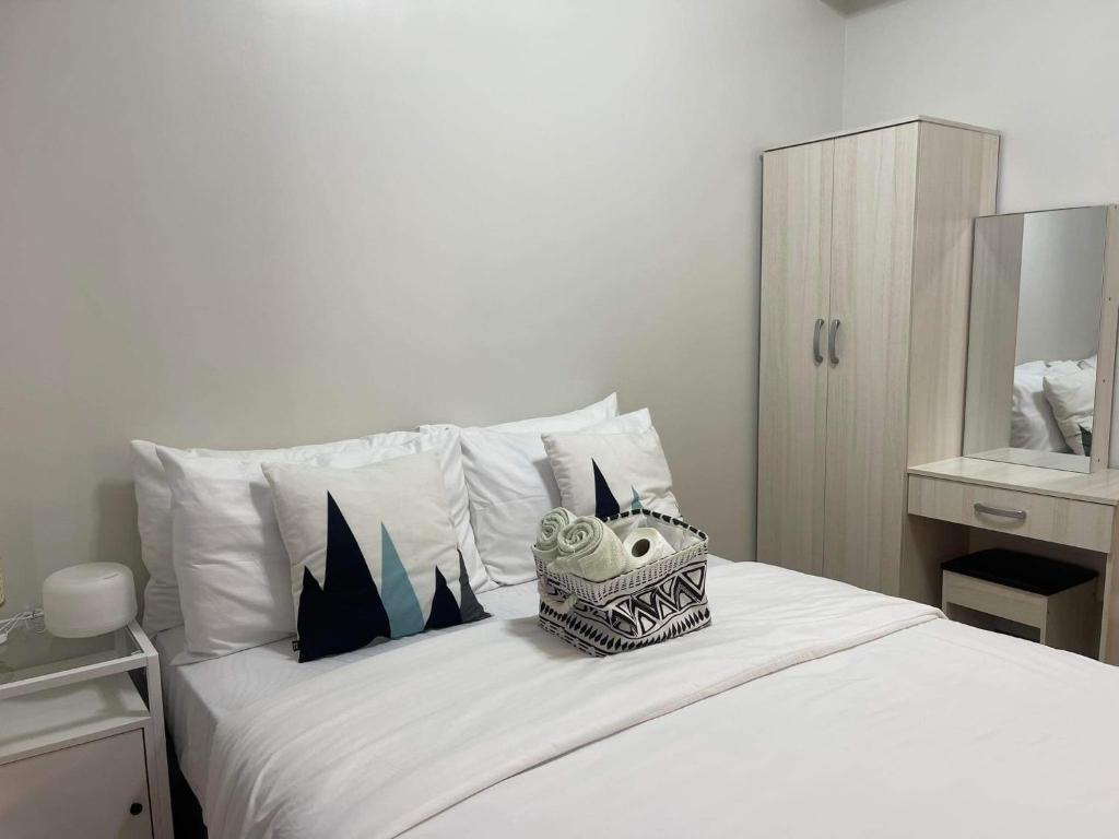 a bedroom with a white bed with aookyooky at Verdon Parc Davao City with Balcony by darpm in Davao City