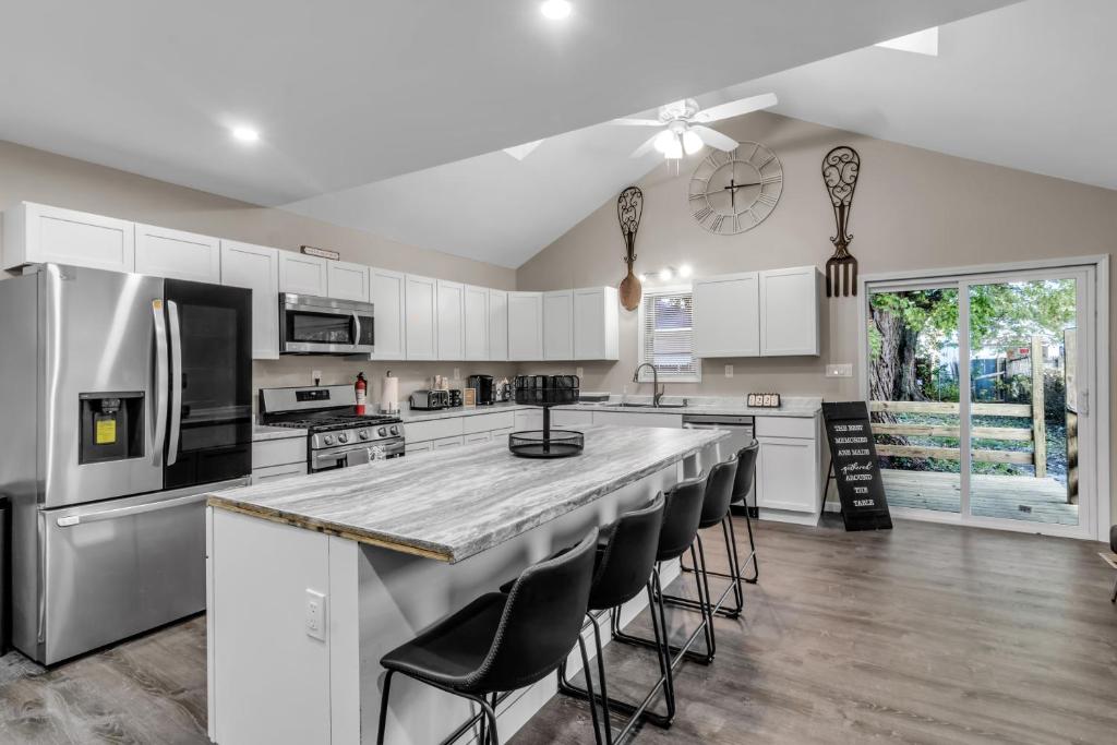 a kitchen with white cabinets and a large island with bar stools at The Davey Retreat in Buffalo