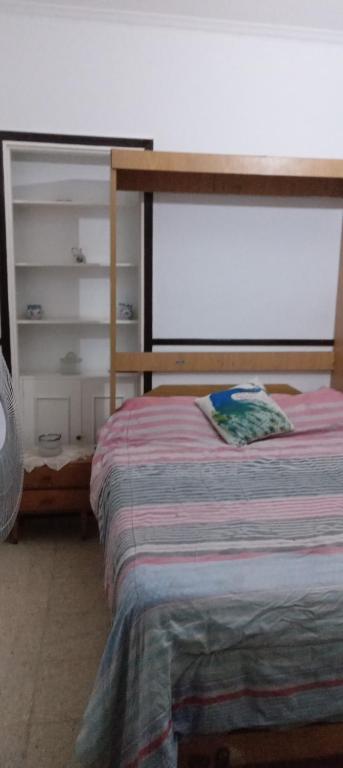 a bedroom with a bed and a book shelf at 8B Ambiente y medio con Balcon in Mar del Plata