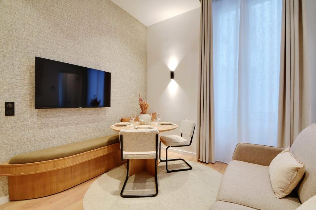 un salon avec une table et une télévision dans l'établissement Dream Home near Sacre Coeur, à Paris
