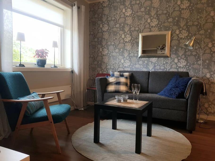 een woonkamer met een bank en een tafel en stoelen bij Leilighet i enebolig på Valderøya ved Ålesund in Ytterland