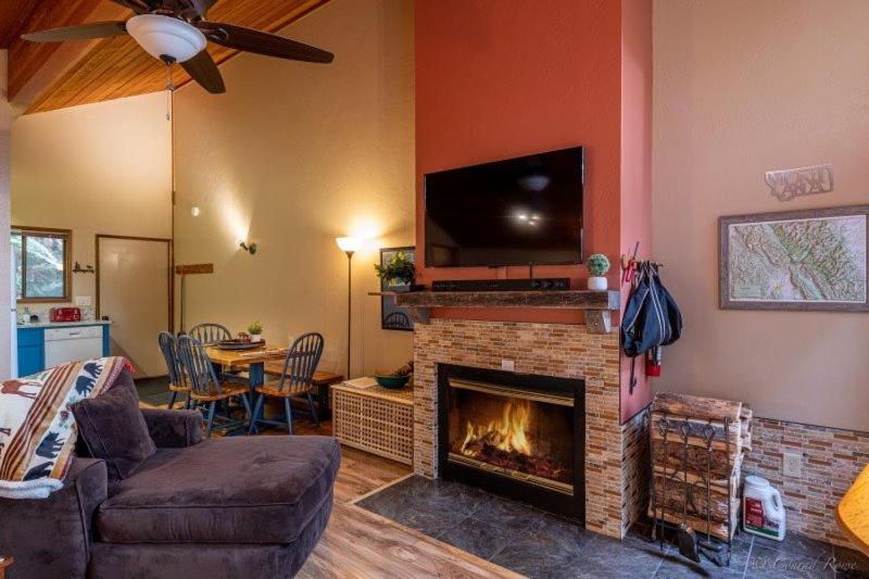 a living room with a fireplace with a flat screen tv at Escape To Ptarmigan Village 86 in Whitefish