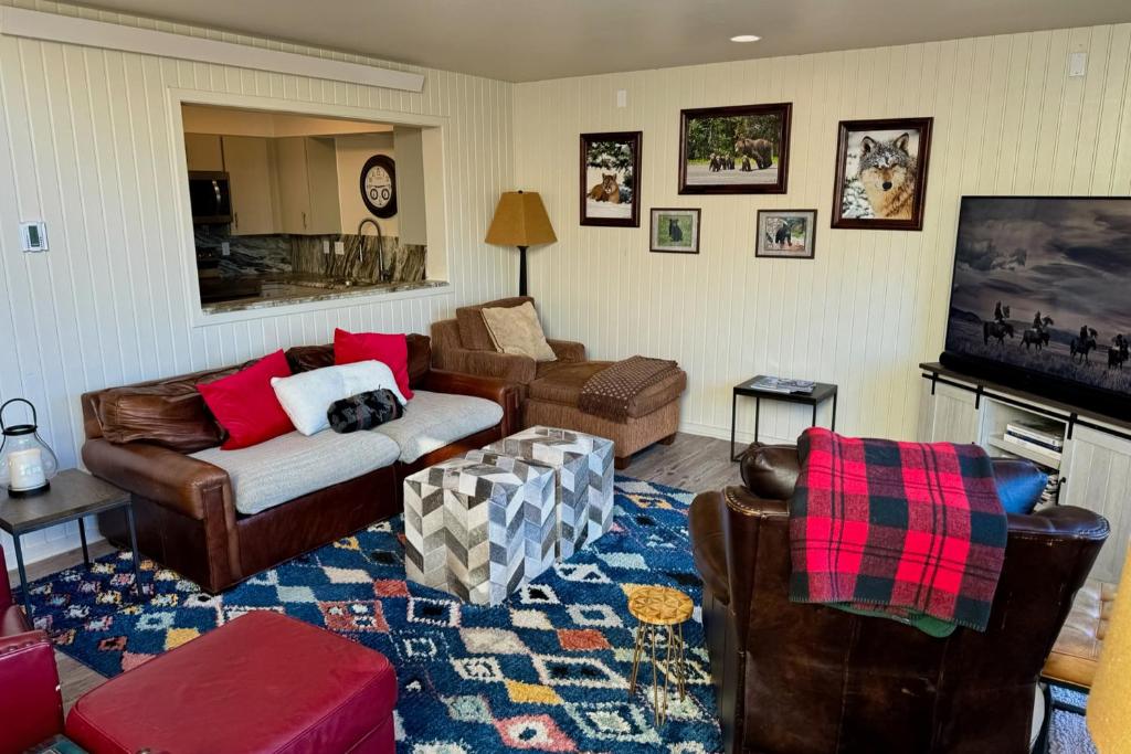 a living room with leather furniture and a tv at Windriver Retreat in Teton Village