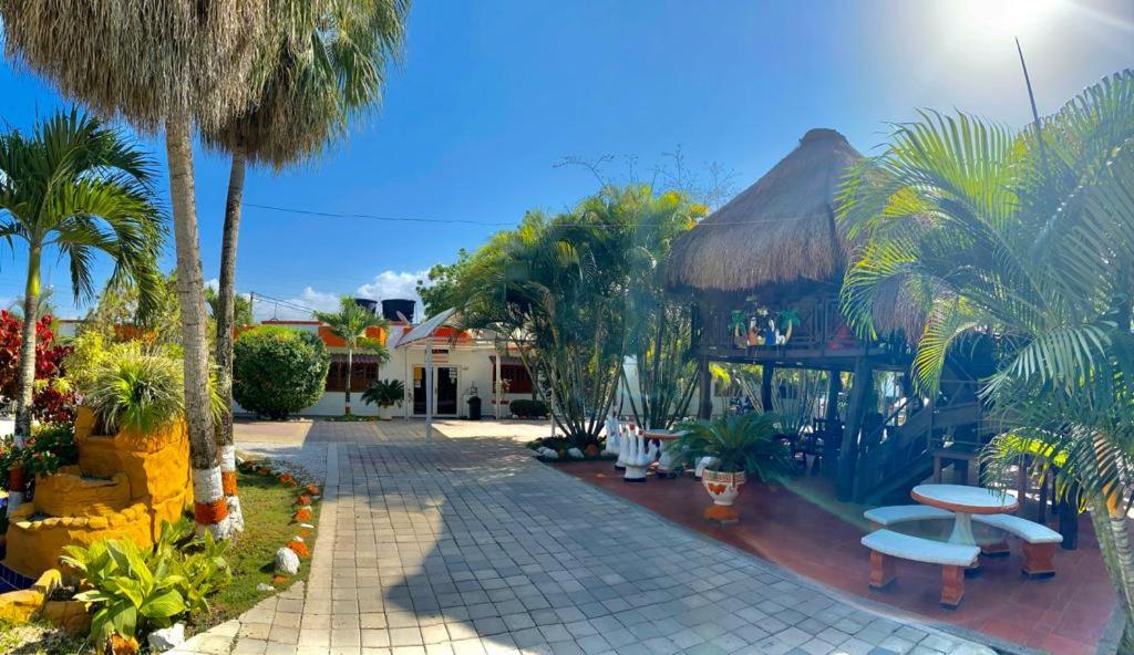 a resort with palm trees and a building with a patio at Hotel Mi Rancho Bonito in Sabanalarga