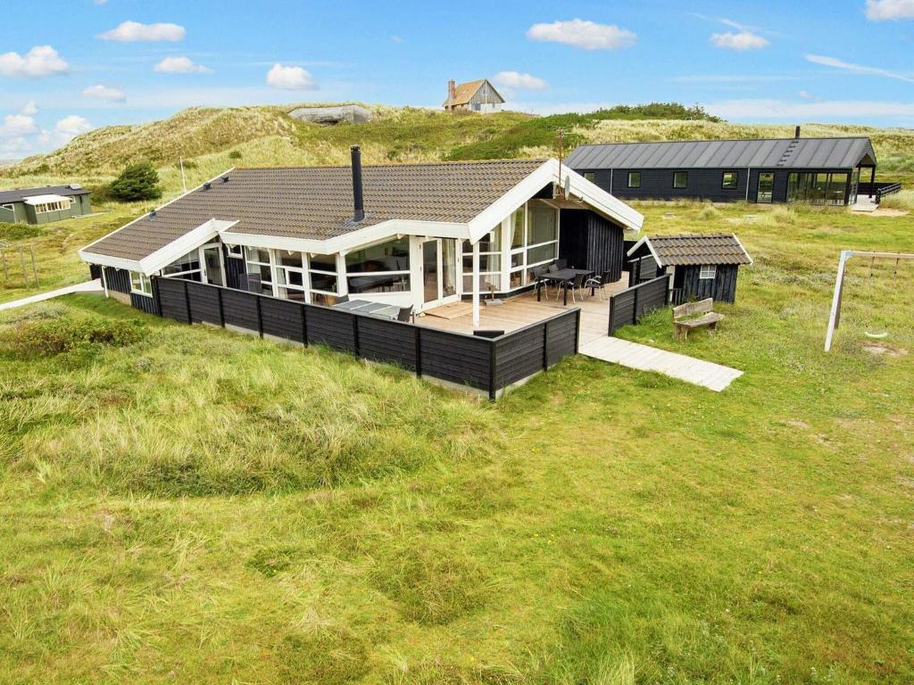 9 person holiday home in Ringk bing في سوندرفيغ: منزل كبير على حقل عشبي مع مبنى