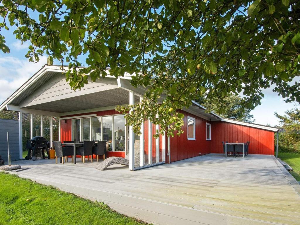 a red house with a deck in front of it at Holiday home Struer XII in Struer