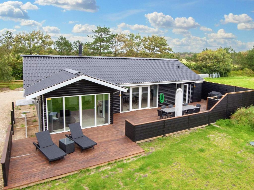 ein Haus mit einer Terrasse und zwei Stühlen darauf in der Unterkunft Holiday home Vemb III in Vemb