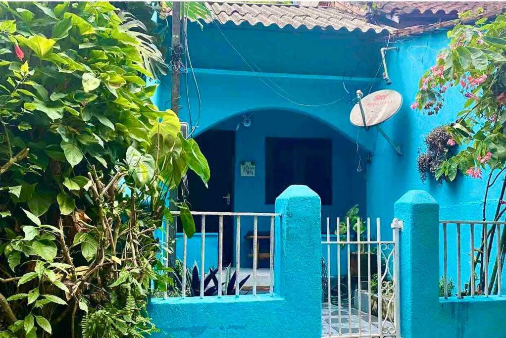 una casa azul con una puerta delante de ella en BLUE HOUSE CONEXÃO ILHA GRANDE en Ilha Grande