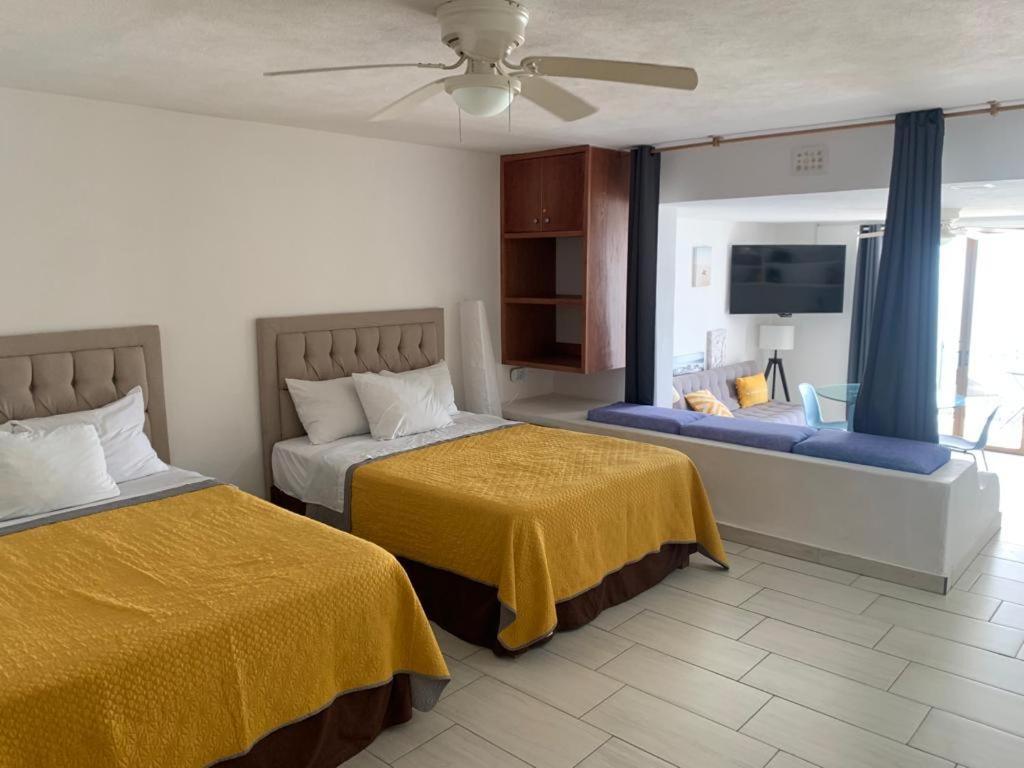 Habitación de hotel con 2 camas y TV en BEACHFRONT 14 Floor, en Puerto Vallarta